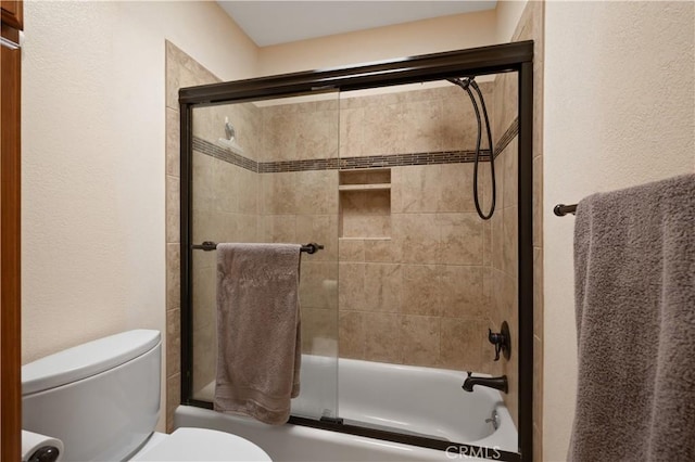 full bath with toilet and bath / shower combo with glass door