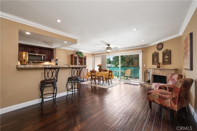 living room featuring crown molding, baseboards, dark wood-style flooring, and recessed lighting