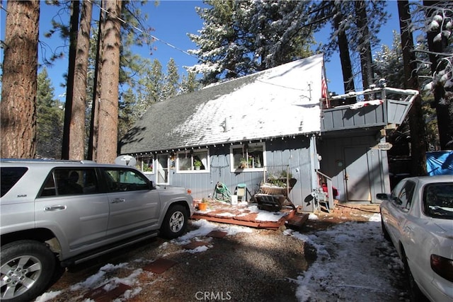 view of side of home with roof with shingles