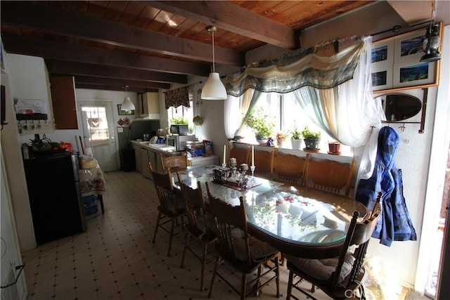 dining area with wooden ceiling, light floors, and beamed ceiling