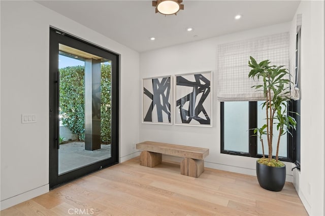 doorway to outside featuring baseboards, light wood finished floors, and recessed lighting