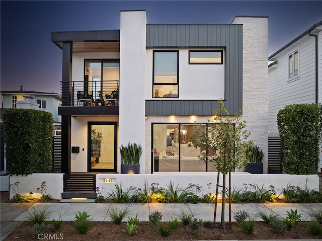 contemporary home with a balcony and stucco siding