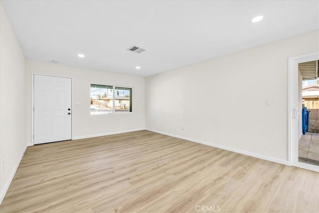 unfurnished room with light wood-type flooring, visible vents, and recessed lighting