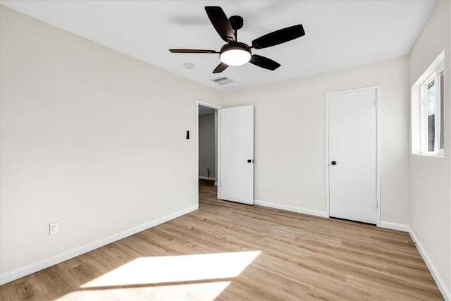 unfurnished bedroom featuring light wood-style floors, visible vents, ceiling fan, and baseboards