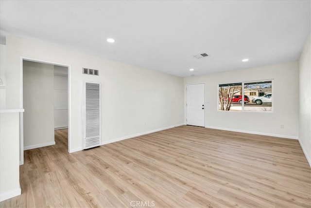 spare room with baseboards, light wood-style flooring, visible vents, and recessed lighting