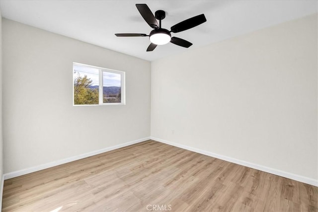 empty room with light wood-style floors, ceiling fan, and baseboards