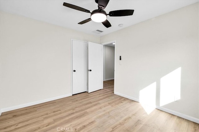 unfurnished bedroom featuring baseboards, visible vents, ceiling fan, and light wood finished floors