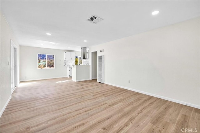 unfurnished living room featuring light wood-type flooring, visible vents, and recessed lighting