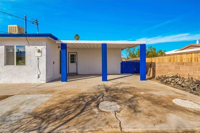 exterior space featuring a patio, central AC unit, fence, and stucco siding