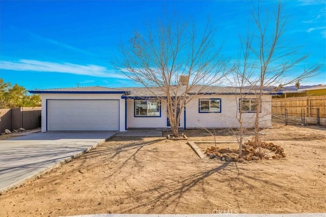 single story home with concrete driveway, an attached garage, fence, and stucco siding