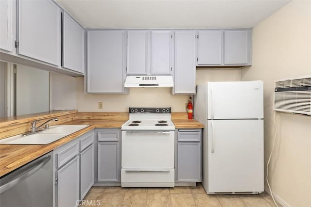 kitchen featuring white appliances, a wall unit AC, butcher block countertops, under cabinet range hood, and a sink