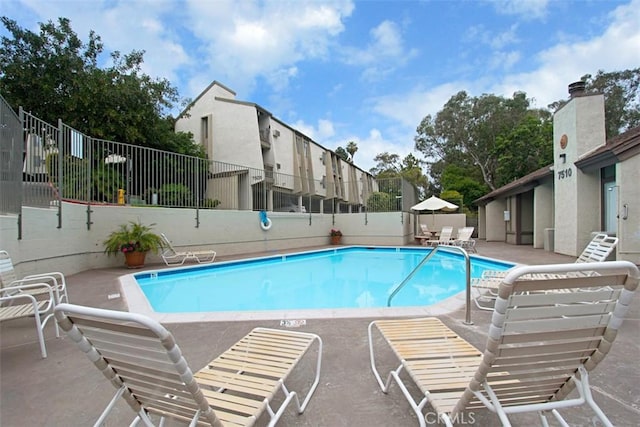 pool featuring a patio area and fence