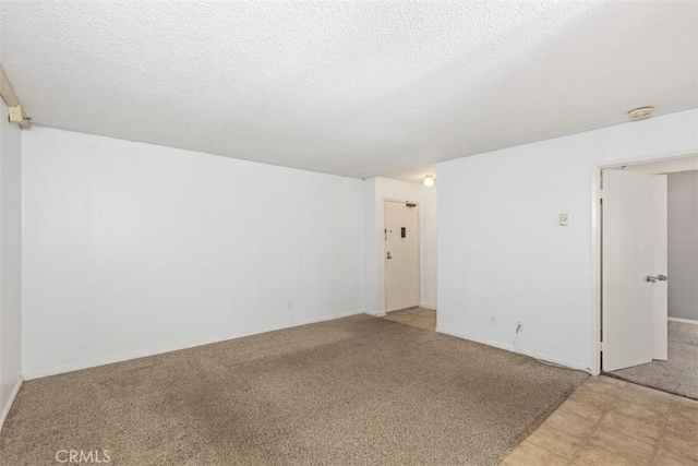 unfurnished room featuring a textured ceiling and light colored carpet