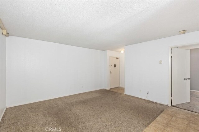7506 Parkway Dr Unit 104, La Mesa, CA 91942 - unfurnished room with light carpet, a textured ceiling, and a smoke detector