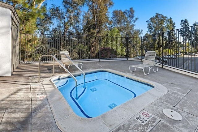 view of swimming pool featuring a patio area and fence