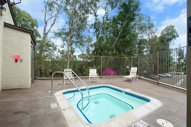 view of pool with a patio area, a hot tub, and fence