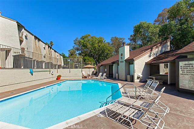 community pool featuring a patio and fence