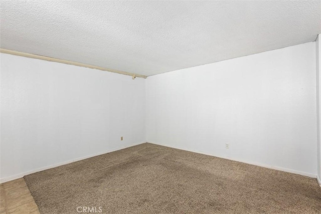 spare room featuring a textured ceiling and carpet