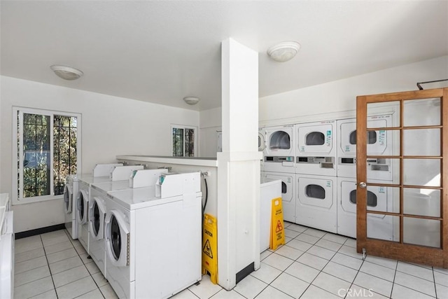 common laundry area with ornate columns, light tile patterned flooring, washing machine and clothes dryer, and stacked washer / drying machine