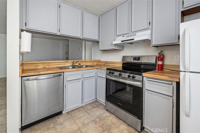 7506 Parkway Dr Unit 104, La Mesa, CA 91942 - kitchen featuring stainless steel appliances, under cabinet range hood, wooden counters, and a sink