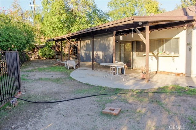 rear view of house with a patio area and fence