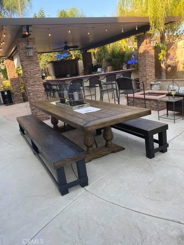 view of patio / terrace with a ceiling fan and exterior bar