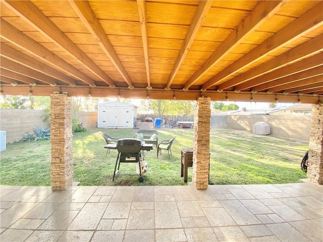 view of patio / terrace featuring an outbuilding, a fenced backyard, grilling area, and a storage shed