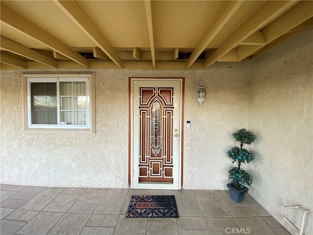 entrance to property featuring stucco siding