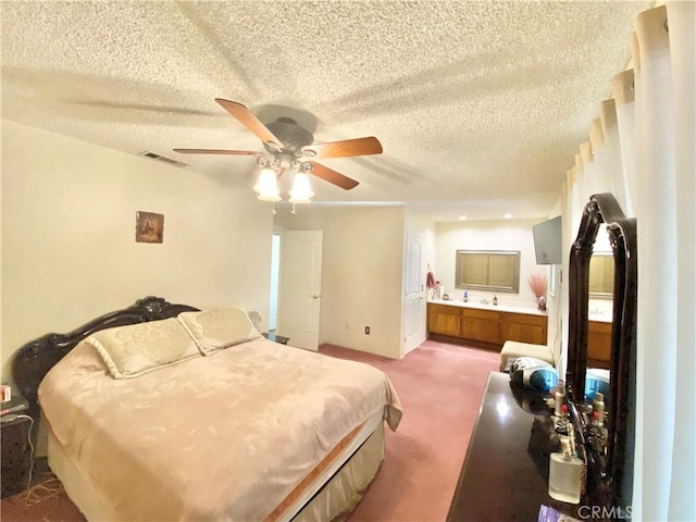 carpeted bedroom with a ceiling fan, a textured ceiling, visible vents, and connected bathroom