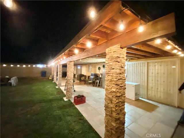 patio at night with a yard and fence