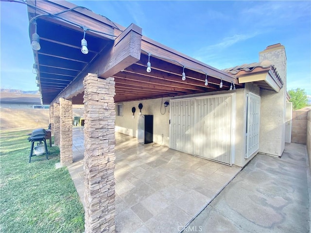 exterior space with a patio, a water view, and stucco siding