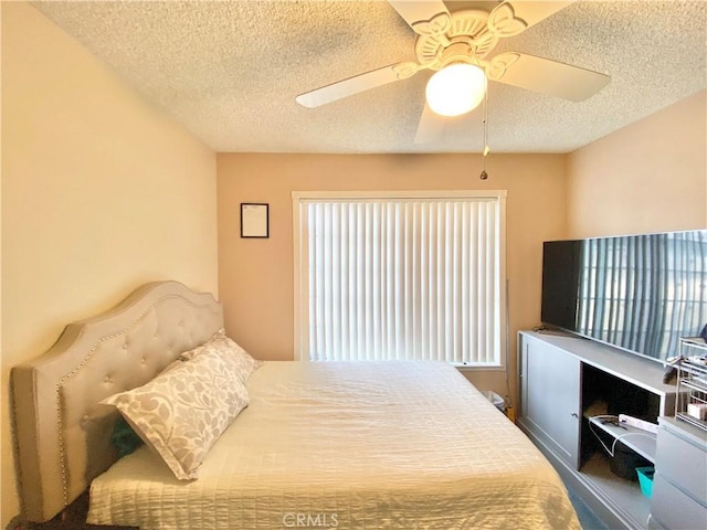 bedroom featuring multiple windows, a ceiling fan, and a textured ceiling