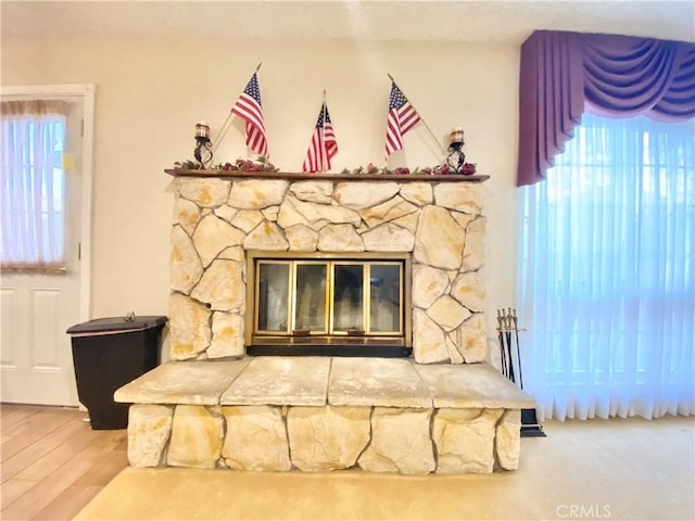 room details featuring a stone fireplace and wood finished floors