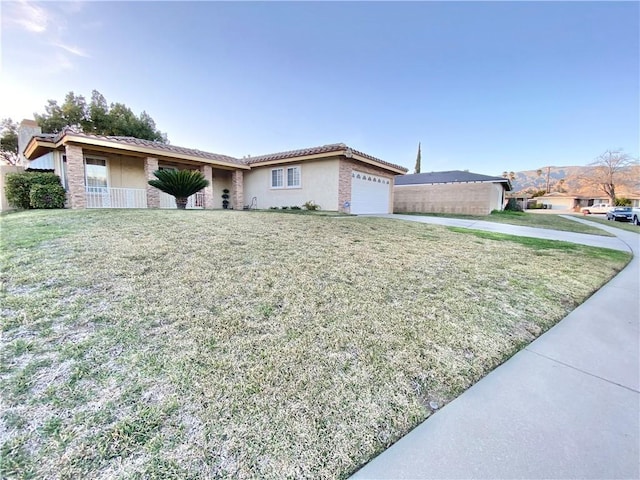 ranch-style home featuring a garage, stucco siding, concrete driveway, and a front yard