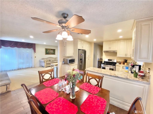 dining area with a textured ceiling, wood finished floors, and recessed lighting