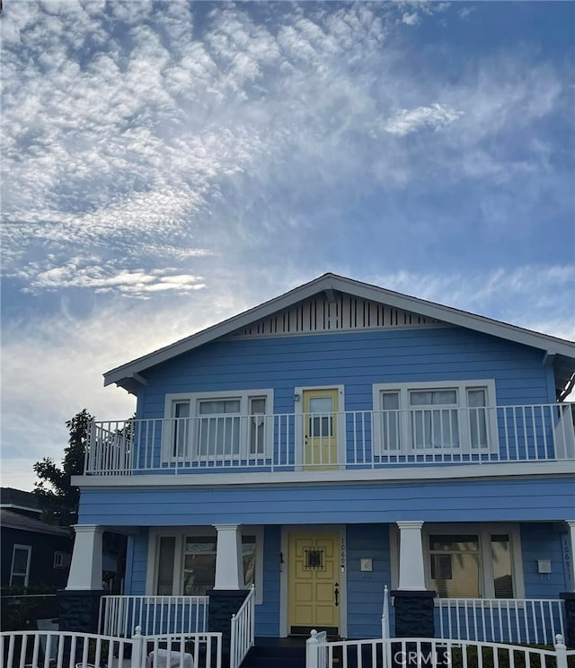 view of front of house with covered porch, board and batten siding, and a balcony