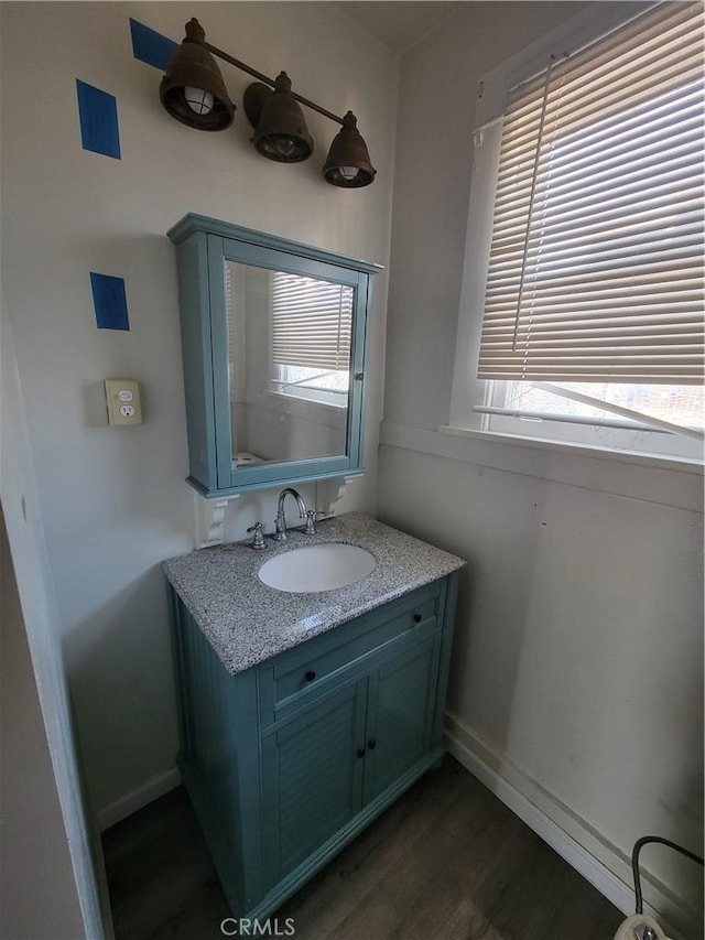 bathroom featuring vanity, baseboards, and wood finished floors