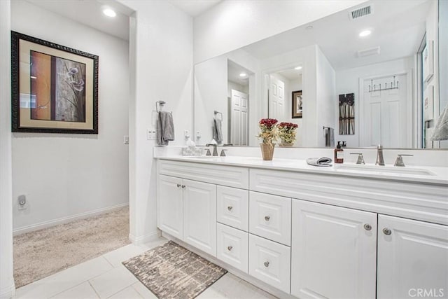 bathroom with visible vents, a sink, baseboards, and double vanity