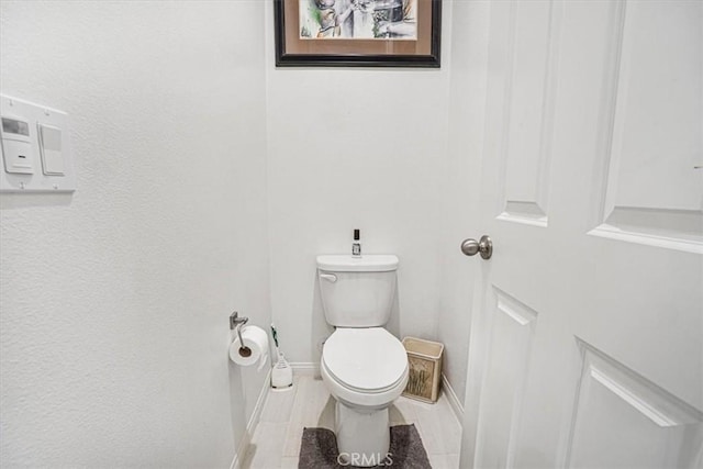 bathroom with baseboards and toilet