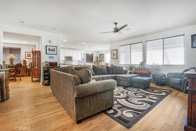 living room with ceiling fan, light wood-type flooring, and recessed lighting