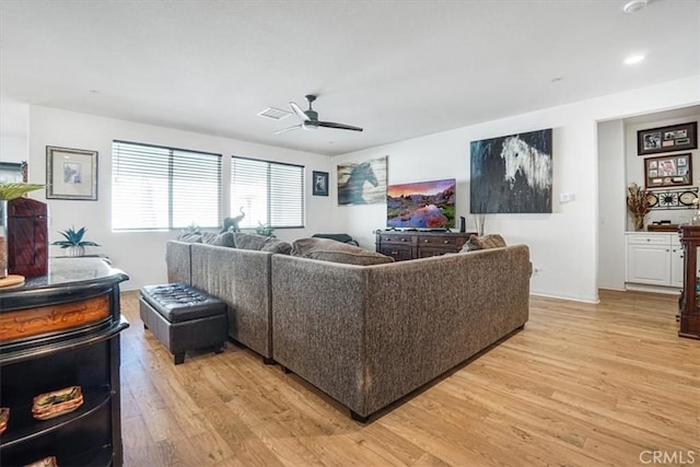 living area featuring light wood-style flooring, visible vents, and ceiling fan