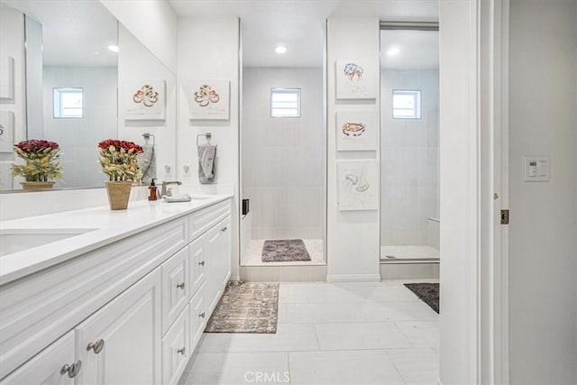 full bath featuring a stall shower, plenty of natural light, a sink, and double vanity