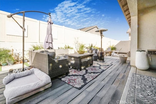 wooden deck with a fenced backyard and an outdoor living space