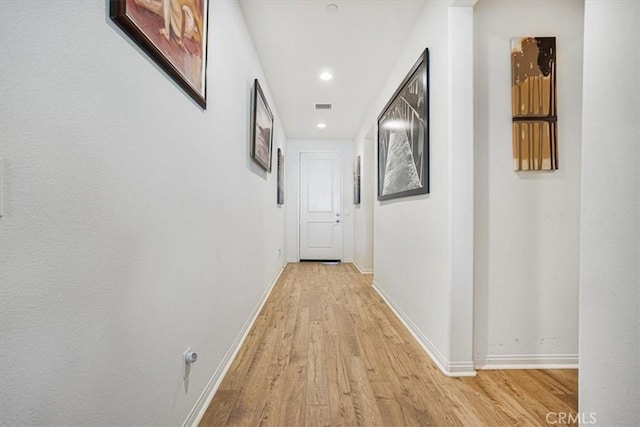 hall with light wood-type flooring, visible vents, baseboards, and recessed lighting