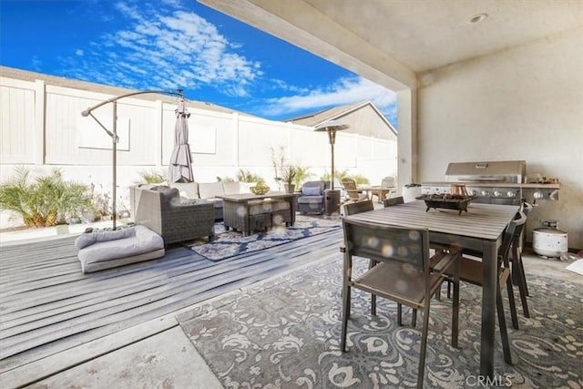 view of patio featuring a wooden deck, a fenced backyard, an outdoor living space, and outdoor dining space