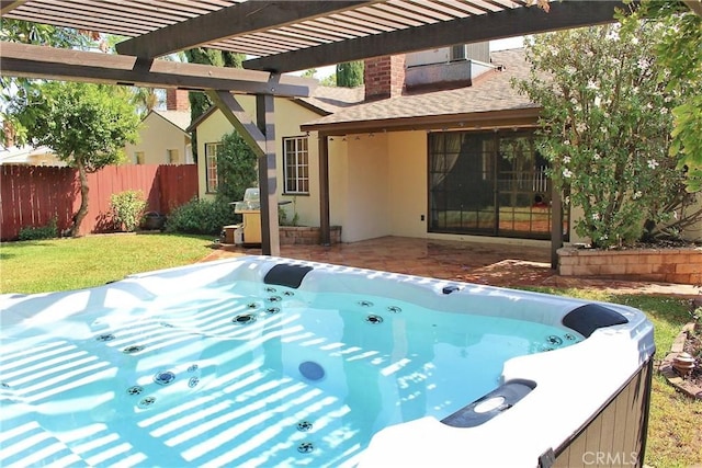 view of swimming pool featuring a patio, fence, a yard, a pergola, and a hot tub