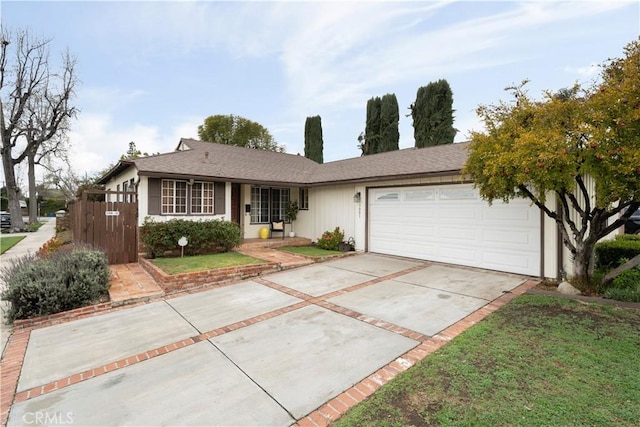 ranch-style home featuring concrete driveway, an attached garage, fence, and a front yard