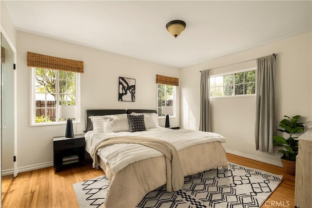 bedroom featuring light wood-style flooring and baseboards