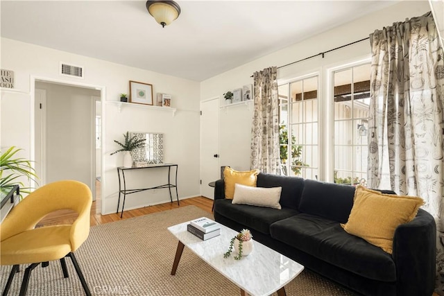 living area featuring wood finished floors and visible vents