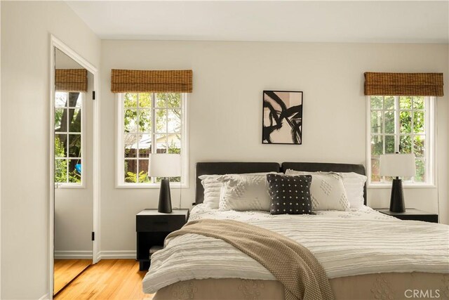 bedroom with baseboards and wood finished floors